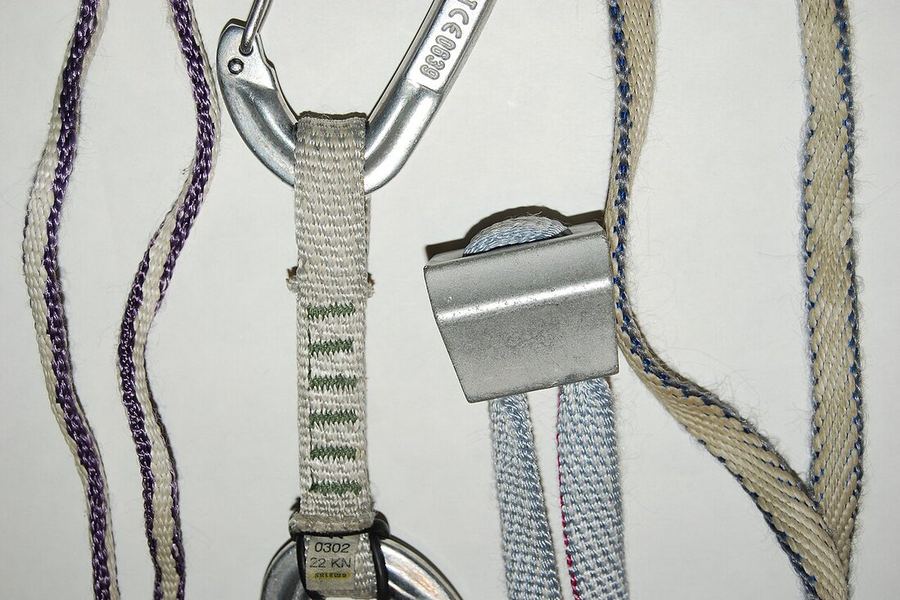 Anneaux et sangles en Dyneema, étroits et blancs à liseré de couleur, dont une sangle de dégaine cousue passée dans un mousqueton