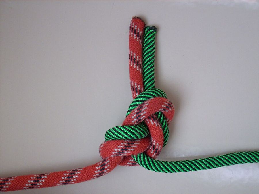 Deux cordes, rouge et verte, jointes par un huit dont les deux bouts libres sortent ensemble du même côté, parallèles