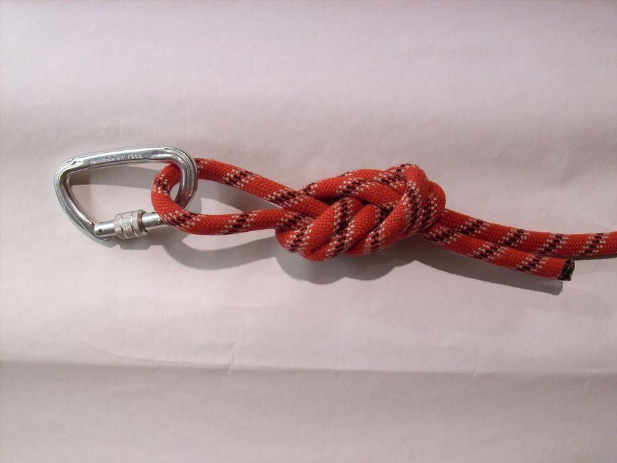 Boucle de nœud de huit passée dans un mousqueton à vis, sur une corde gainée rouge